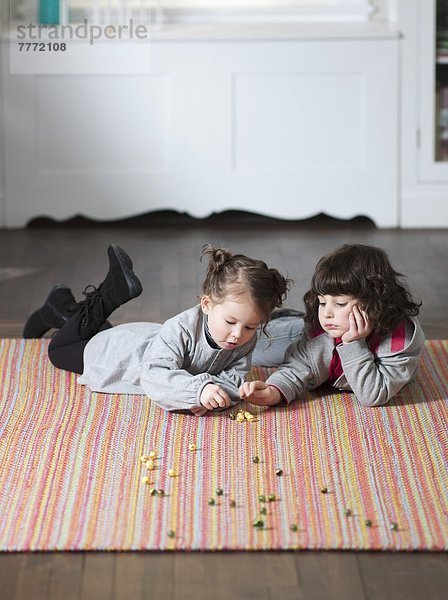 Kinder spielen auf dem Teppich