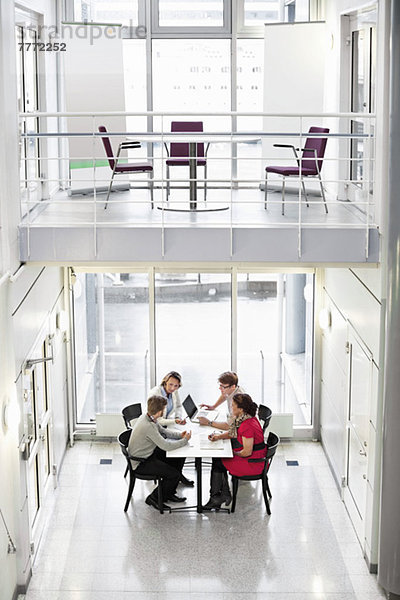 Hohe Blickwinkel von Geschäftsleuten  die am Schreibtisch im Büro diskutieren