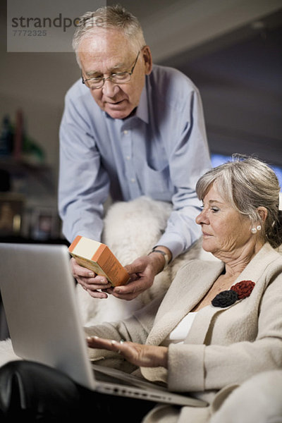 Senior Paar überprüft Produktdetails auf dem Laptop