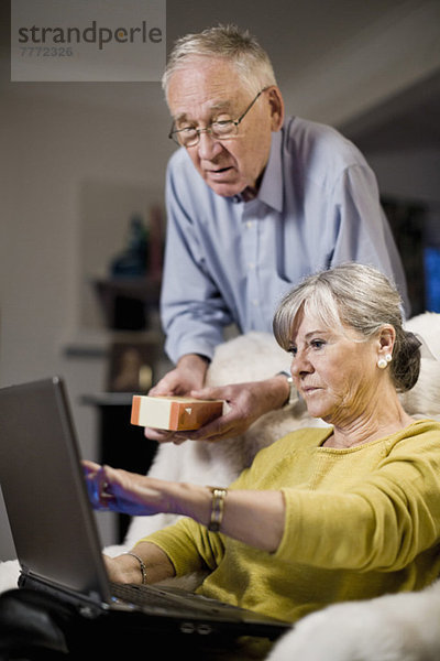 Senior Paar überprüft Produktinformationen auf dem Laptop