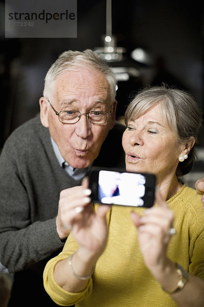 Senioren-Paar macht Gesichter beim Selbstporträt per Handy