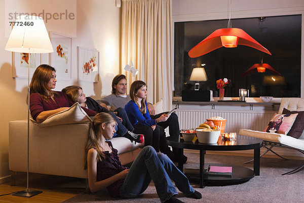 Familie beim gemeinsamen Fernsehen im Wohnzimmer
