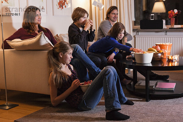 Fünfköpfige Familie beim gemeinsamen Fernsehen im Wohnzimmer