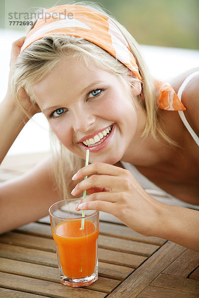 Portrait Frau lächelnd  auf Ponton  Fruchtsaft trinken  Strohhalm