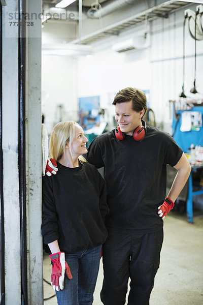 Mechanikerinnen und Mechaniker schauen sich in der Werkstatt an.