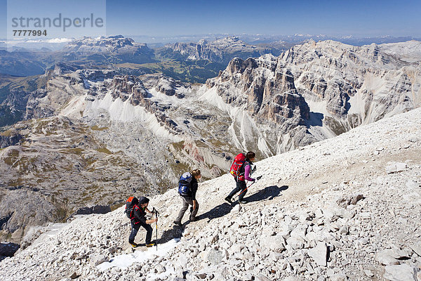 Bergsteiger beim Aufstieg auf die Tofana di Rozes über die Via ferrata Giovanni Lipella  hinten der Sellastock und das Grödnerjoch  Dolomiten