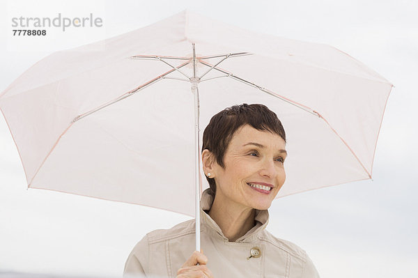 Regenmantel  Portrait  Frau  lächeln  Regenschirm  Schirm  halten  Kleidung