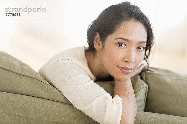 Portrait einer jungen Frau auf Couch sitzen