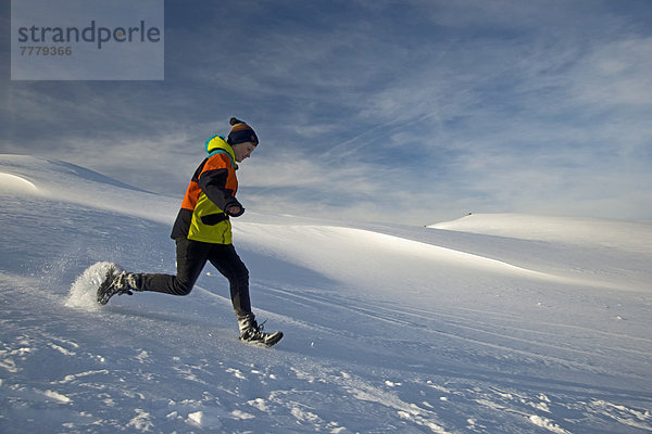 Zwölfjähriger Junge rennt durch den Schnee