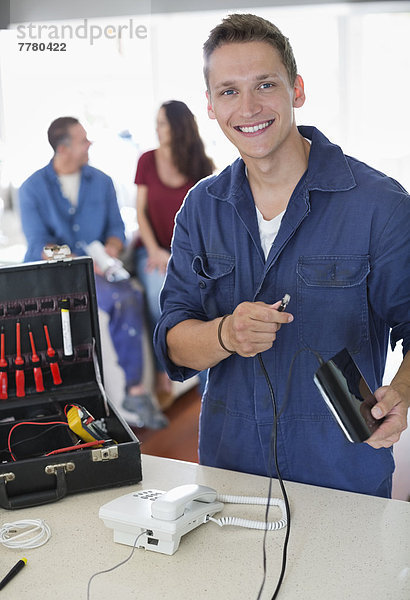 Elektriker  der zu Hause am Telefon arbeitet