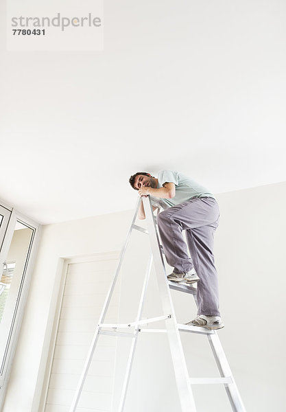 Mann klettert Leiter im Haus