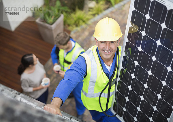 Arbeiter installiert Solarmodul auf dem Dach