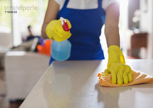 Frau reinigt Küchenarbeitsplatte