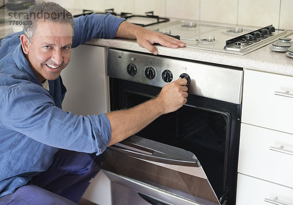 Elektriker bei der Arbeit am Ofen in der Küche