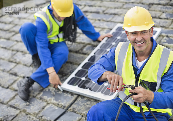 Arbeiter installieren Solarpanel auf dem Dach