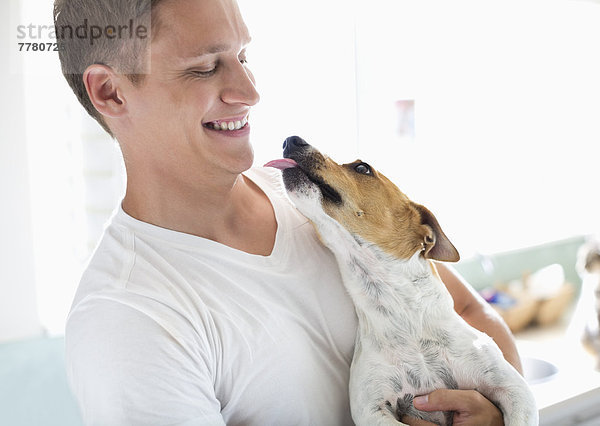 Lächelnder Mann hält Hund