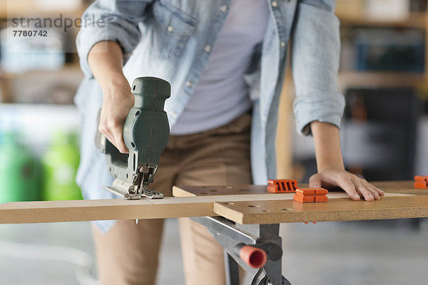 Frau  die in der Werkstatt arbeitet