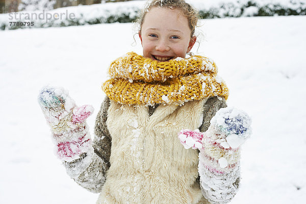 Lächelndes Mädchen spielt im Schnee