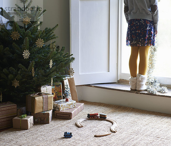 Mädchen mit Weihnachtsbaum und Geschenken