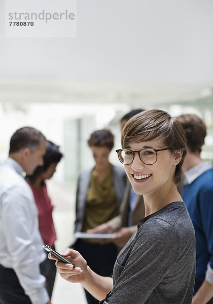 Geschäftsfrau mit Handy im Meeting