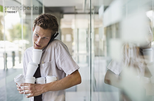 Geschäftsmann beim Kaffeebalancieren im Büro