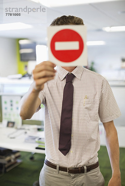 Geschäftsmann mit Warnschild im Amt