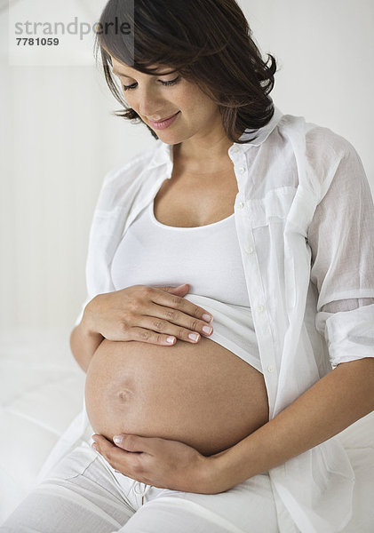 Schwangere Frau  die ihren Bauch hält.