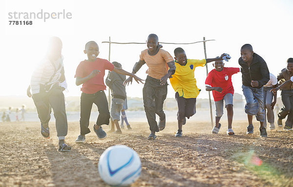 Jungs spielen zusammen Fußball auf dem Feld.