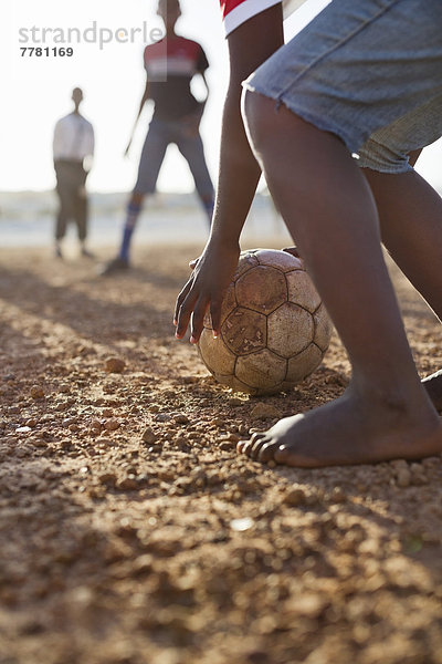 Jungs spielen zusammen Fußball auf dem Feld.