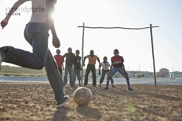 Jungs spielen zusammen Fußball auf dem Feld.