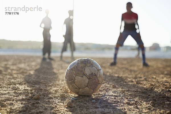 Jungs spielen zusammen Fußball auf dem Feld.