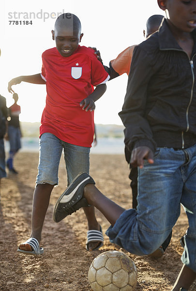 Jungs spielen zusammen Fußball auf dem Feld.