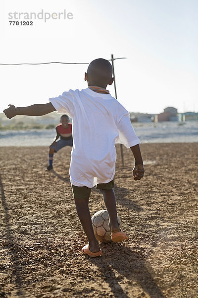 Jungs spielen zusammen Fußball auf dem Feld.