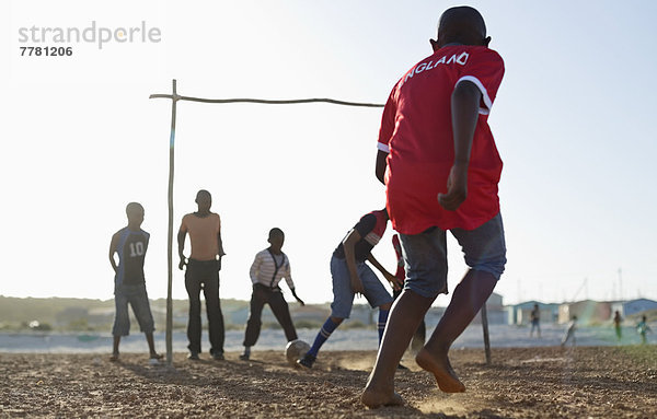 Jungs spielen zusammen Fußball auf dem Feld.