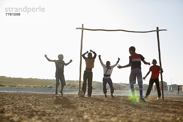 Jungs spielen zusammen Fußball auf dem Feld.