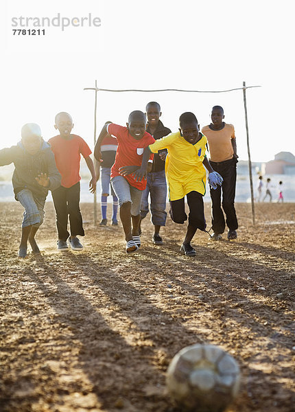 Jungs spielen zusammen Fußball auf dem Feld.