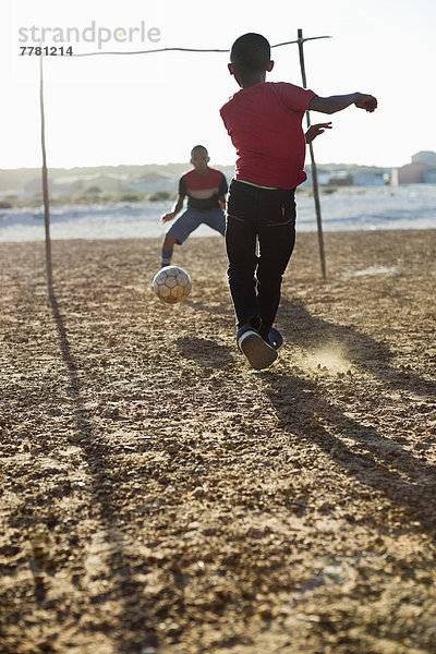 Jungs spielen zusammen Fußball auf dem Feld.