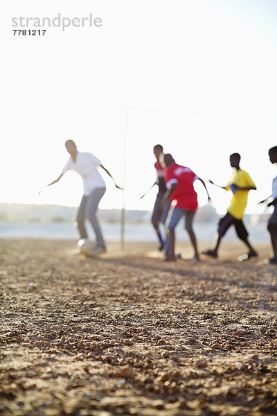 Jungs spielen zusammen Fußball auf dem Feld.