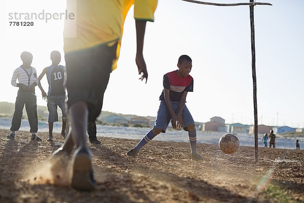 Jungs spielen zusammen Fußball auf dem Feld.