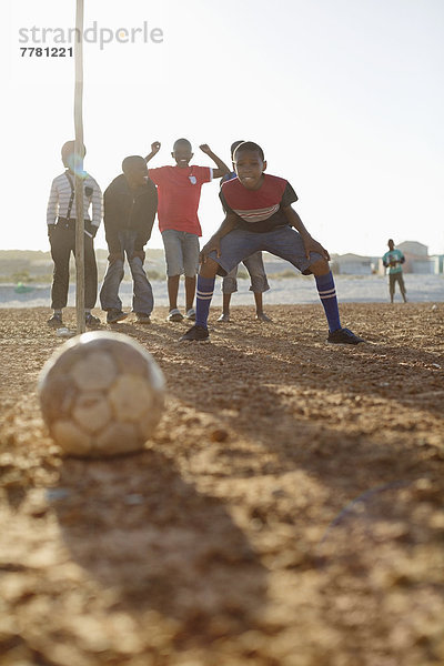 Jungs spielen zusammen Fußball auf dem Feld.