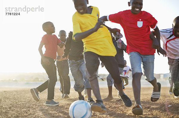 Jungs spielen zusammen Fußball auf dem Feld.