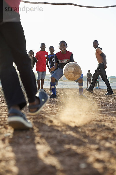 Jungs spielen zusammen Fußball auf dem Feld.