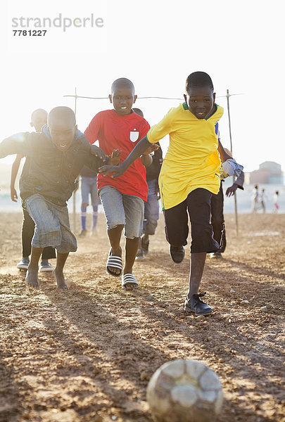 Jungs spielen zusammen Fußball auf dem Feld.