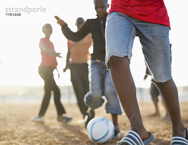 Jungs spielen zusammen Fußball auf dem Feld.