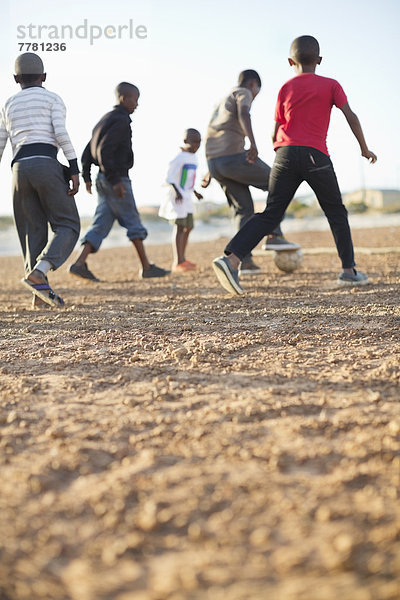 Jungs spielen zusammen Fußball auf dem Feld.