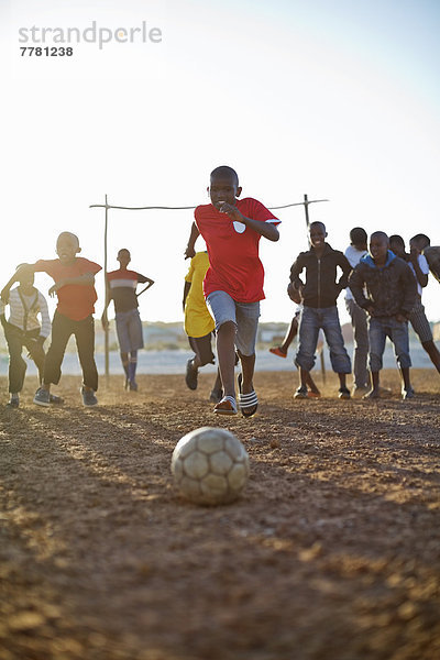 Jungs spielen zusammen Fußball auf dem Feld.