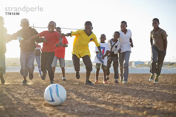 Jungs spielen zusammen Fußball auf dem Feld.