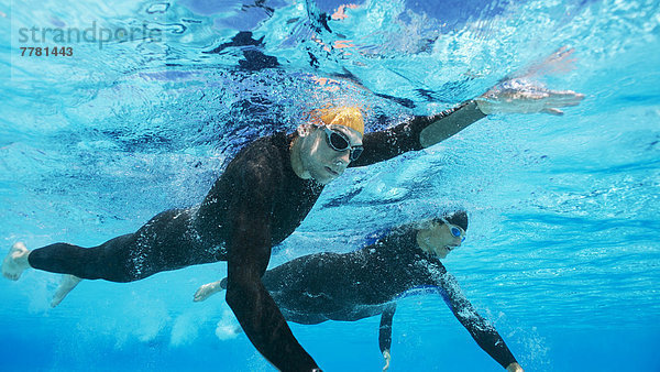 Triathleten in Trikots unter Wasser