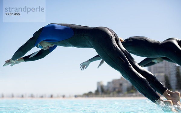 Triathleten beim Eintauchen ins Schwimmbad