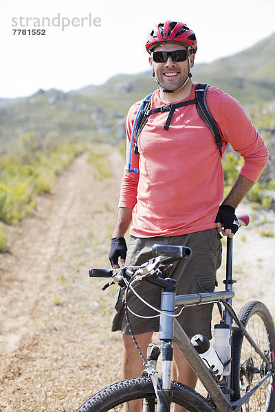 Mountainbiker lächelnd auf dem Feldweg